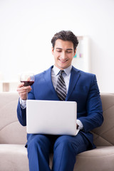 Businessman drinking wine sitting at home