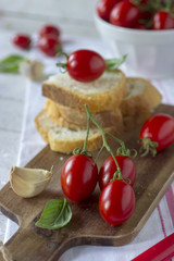 Pomodorini in primo piano e fette di pane nello sfondo