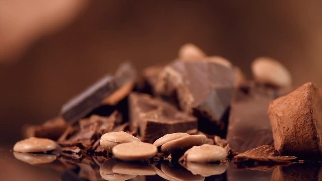 Chocolate. Assorted chocolate sweets and candies rotated over dark background. Confectionery. 4K UHD video 3840X2160