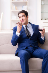 Businessman drinking wine sitting at home