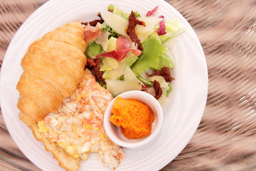 Scrambled eggs with dried tomatoes, fresh salad and little and bean hummus