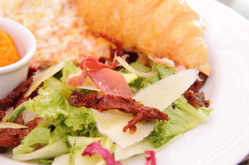 Scrambled eggs with dried tomatoes, fresh salad and little and bean hummus