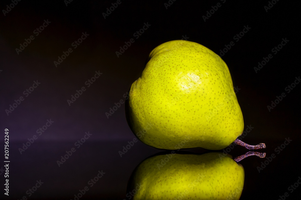 Wall mural ripe juicy pear on black background