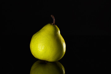Fototapeta na wymiar ripe juicy pear on black background