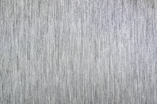 Close up industrial background of fractally scratched direct vertical lines to silver metal/stainless steel surface. Creative detail macro photography.