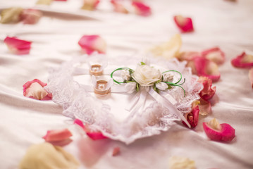wedding engagement rings lie in a pillow
