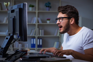 Fototapeta premium Young man staying late in office to do overtime work
