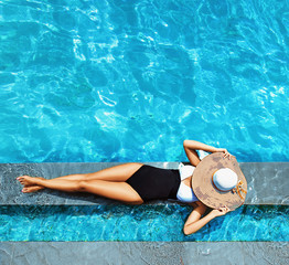 Sexy lady relaxing by the swimming - pool