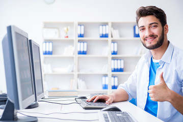 Businessman sitting in front of many screens