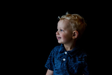 Toddler looking towards light on a dark background