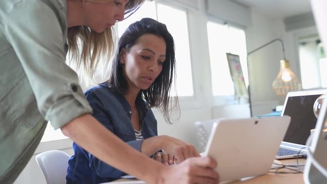 Businesswomen working together on laptop