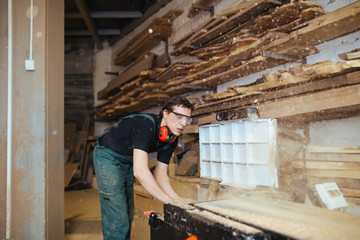 Young master carpenter working in his woodwork or workshop. 