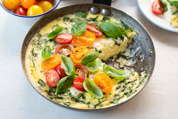 Basil frittata with halloumi, mixed tomatoes and basil leaves