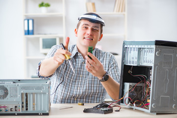 Young technician repairing computer in workshop