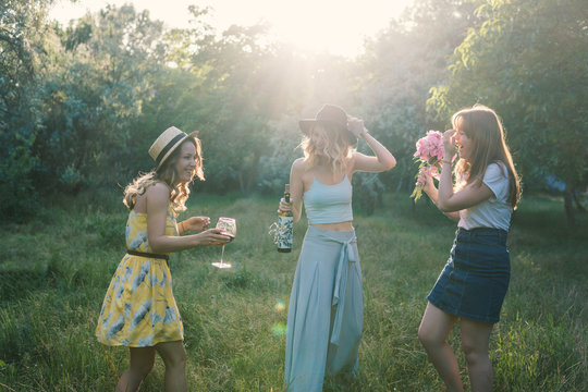 Group of girls friends making picnic outdoor. They have fun.