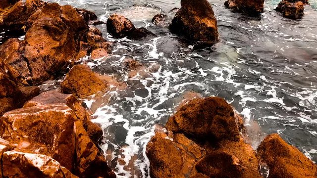 some darken rocks with white waves