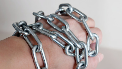 A silver metal chain with its hands closed.