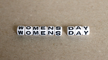 The text WOMENS DAY with white cube.