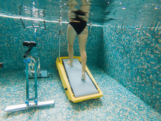 Young woman jogging on an underwater treadmill