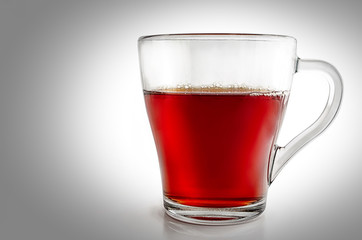 Glass glass of tea on a white background with a vignette.