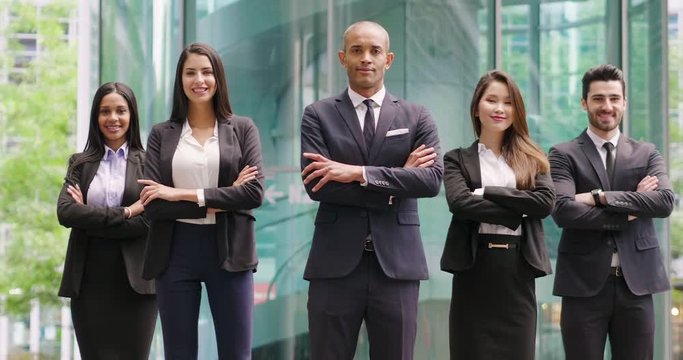 Portrait of business people of different ethnic backgrounds dressed in suits, they smile and cross their arms. Concept of: internationality and career, cooperation and team.