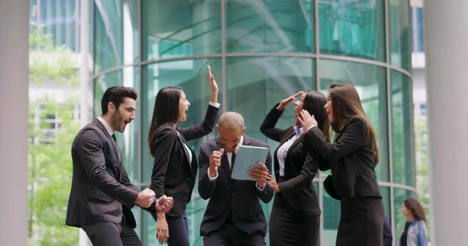 A group of business people from different ethnic backgrounds rejoices and celebrates their success in the financial and economic fields. Concept of: team work, internationality and success.