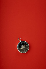 compass on red background top view