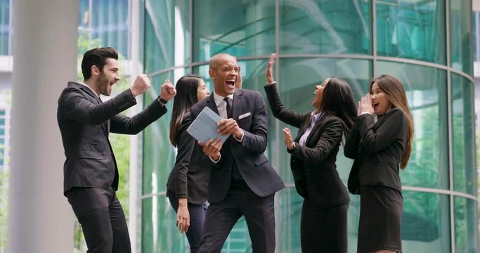 A group of business people from different ethnic backgrounds rejoices and celebrates their success in the financial and economic fields. Concept of: team work, internationality and success.