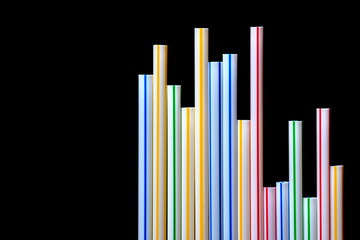 bunte Strohhalme  aus Kunststoff (Plastik) vor schwarzem Hintergrund, Freisteller