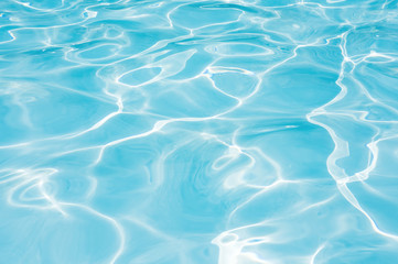 Abstract of blue water surface in swimming pool, Ripple wave in pool with sun reflections