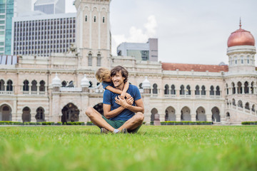 Dad and son on background of Merdeka square and Sultan Abdul Samad Building. Traveling with...
