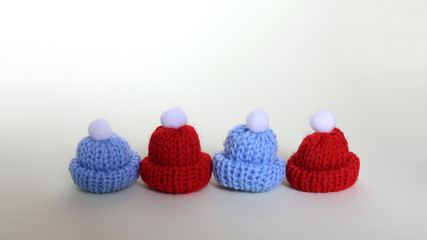A red fur hat and a blue fur hat next to each other.
