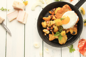 Schnitzel Spiegelei Bratkartoffeln Pfanne frisch gebraten Tisch Speck Zwiebeln