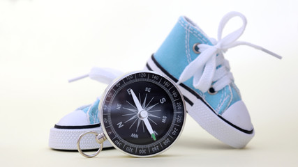 A standing compass and a pair of sky blue sneakers.