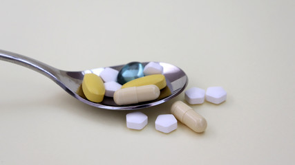 A concept of the importance of proper drug use. The pills and capsules on the spoon.