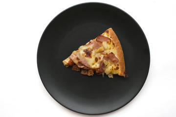 Piece of pizza on black dish