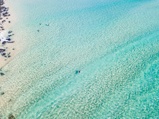 An aerial view of a surfer paddling in blue water on Queensland's Gold Coast in Australia