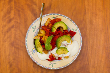 plate with fried vegetables and row avocado