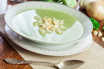 Broccoli cream soup in plate served with croutons