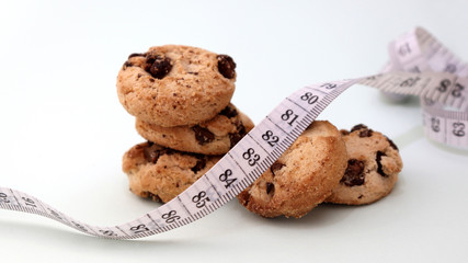 A pile of chocolate cookies and a tape measure.
