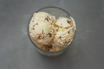 Ice Cream Scoop in Glass Cup isolated over Gray background. homemade Dessert Icecream with Chocolate flakes