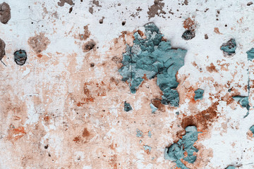 Peeling green paint on the cement wall