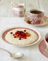 A useful breakfast of rice porridge with strawberry sauce served with tea.