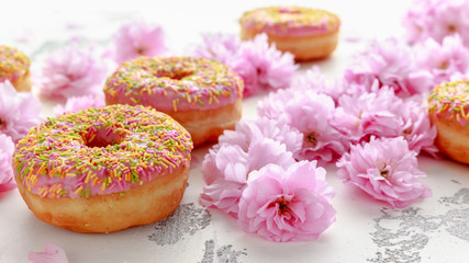 Sweet pink fresh Donut decorated with japanese Flowering Cherry Tree flower