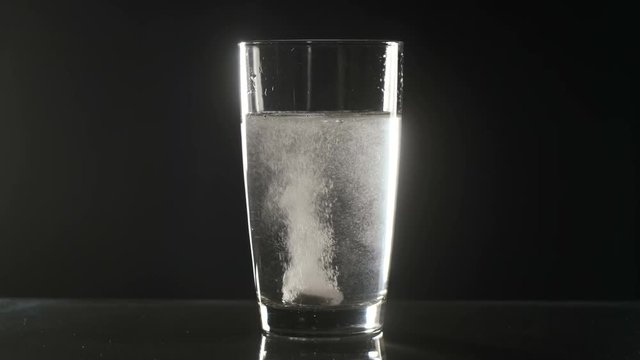 Effervescent tablet falls on a bottom of a glass
