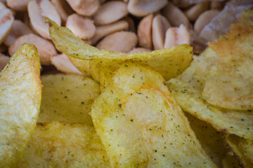 Background of potato chips and fried peanuts. Texture. close-up