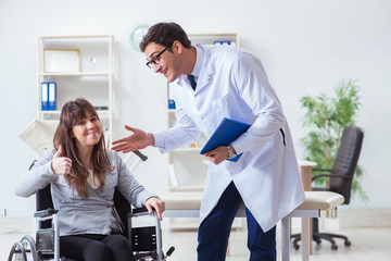 Naklejka premium Male doctor examining female patient on wheelchair