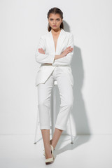 Young woman on a white wall background. High fashion