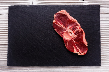 fresh lamb meat on a textured stone plate