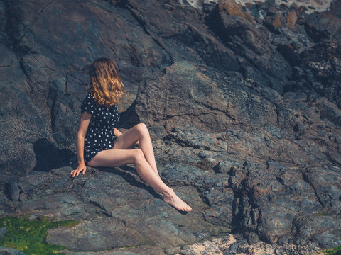 Woman sitting on rocks in summer